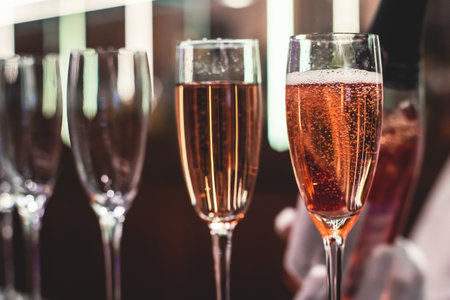 Line of alcohol setting on catering banquet table, bartender pouring beverages, row of different colored alcohol cocktails on a party, martini, vodka, and others on decorated banquet eventの写真素材