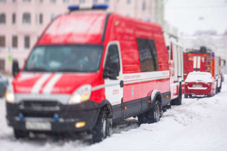 Group of fire men in uniform, firefighters with the a engine truck fighting vehicle in the background, winter streetsの写真素材