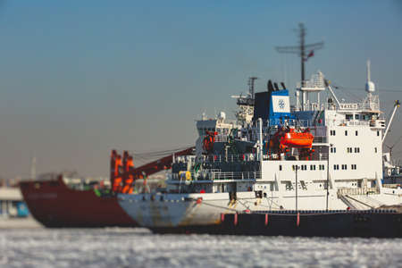 Massive different ship vessels trapped in ice tries to break and leave the bay between the glaciers,...