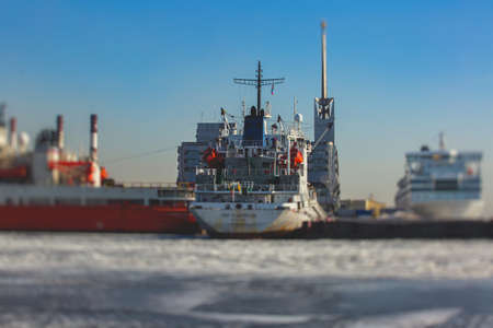 Massive different ship vessels trapped in ice tries to break and leave the bay between the glaciers,...