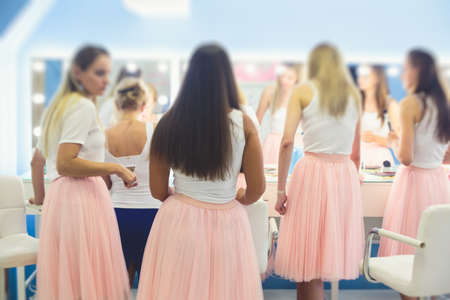 Happy young stylish multiethnic girls having fun during bachelorette bridesmaids party, group of diverse multiracial women dressed in the same colored dresses clothes, party in pink color tonesの写真素材