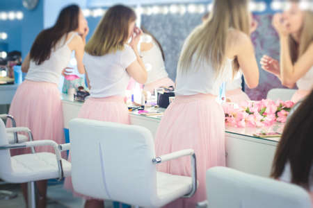 Happy young stylish multiethnic girls having fun during bachelorette bridesmaids party, group of diverse multiracial women dressed in the same colored dresses clothes, party in pink color tonesの写真素材