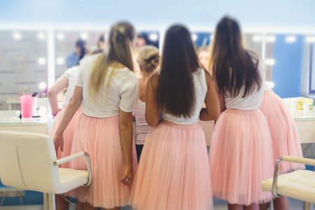 Happy young stylish multiethnic girls having fun during bachelorette bridesmaids party, group of diverse multiracial women dressed in the same colored dresses clothes, party in pink color tonesの写真素材