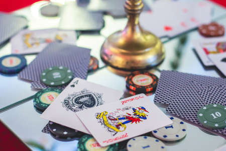 A close-up vibrant image of multicolored casino table with roulette in motion, with casino chips. the hand of croupier, mone and a group of gambling rich wealthy people in a backgroundの写真素材