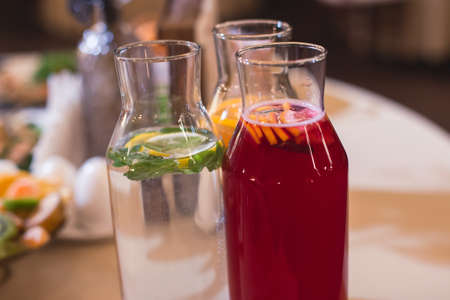 View of alcohol setting on catering banquet table, row line of different colored alcohol cocktails on party, martini, vodka, spritz and others on decorated catering table eventの写真素材