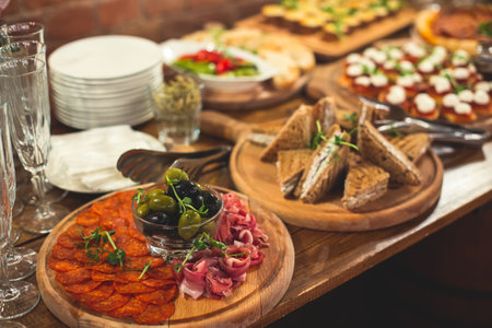 Beautifully decorated catering banquet table with different food snacks and appetizers on corporate christmas birthday party event or wedding reception celebrationの写真素材