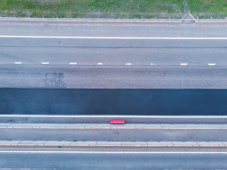 Asphalt paver machine and steam road roller during road construction and repairing works, process of asphalting and paving, workers working on a new road construction site, placing a layer, droneの写真素材