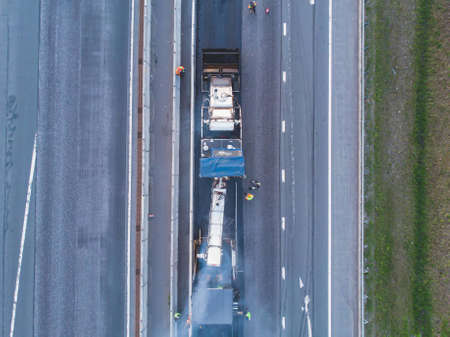 Asphalt paver machine and steam road roller during road construction and repairing works, process of...