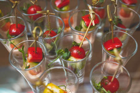 Catering table, beautifully decorated banquet with variety of with different food snacks and appetizers on corporate birthday party event or wedding celebration, canape, delicatessen settingの写真素材