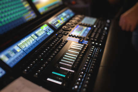 View of lighting technician operator working on mixing console workplace during live event concert...