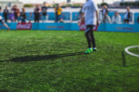 Street football outdoor game on an artificial astroturf vibrant lawn, soccer game on a pitch field with a team in a backgroundの写真素材