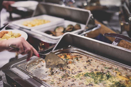 Beautifully decorated catering banquet table with different main course hot food dishes and garnish, with rice, chicken, lamb, vegetables and kebab on corporate party event or christmas celebrationの写真素材