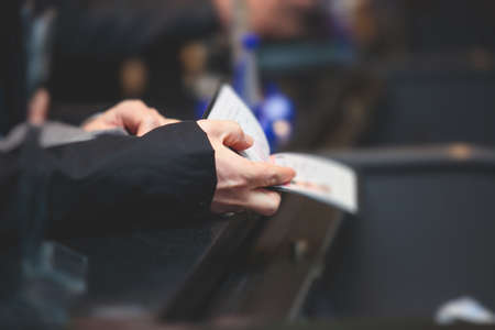 Process of checking in on conference congress forum event, registration desk table, visitors and attendees receiving a name badge and entrance wristband bracelet and register electronic ticket,の写真素材