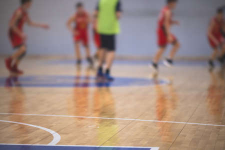 View of basketball court hall indoor venue with junior teenage school team playing in the background, basketball match game on the arena stadium, team is blurred with copy spaceの写真素材