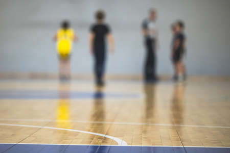 View of basketball court hall indoor venue with junior teenage school team playing in the background, basketball match game on the arena stadium, team is blurred with copy spaceの写真素材