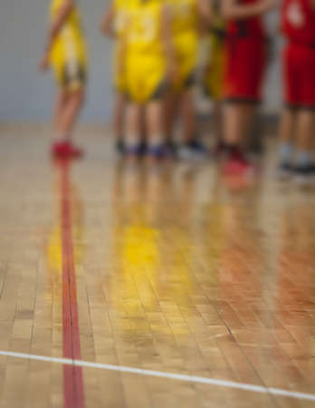 View of basketball court hall indoor venue with junior teenage school team playing in the background, basketball match game on the arena stadium, team is blurred with copy spaceの写真素材