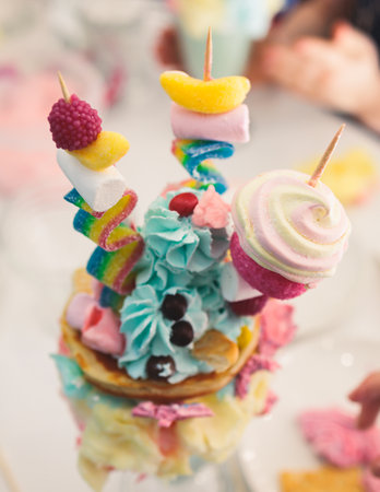 Over shake and freak shake, process of cooking extreme colorful milkshakes on a kids birthday party event celebration, catering banquet table with candy sweets desserts, monster shakesの写真素材