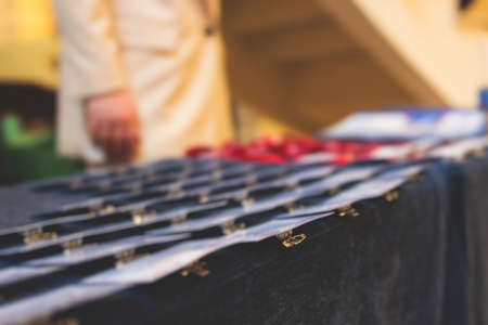Process of checking in on a conference congress forum event, registration desk table, visitors and attendees receiving a name badge and entrance wristband bracelet and register an electronic ticketの写真素材