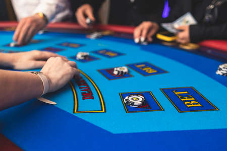 Poker table view with a pack of cards, tokens, alcohol drinks, dollar money and group of gambling...