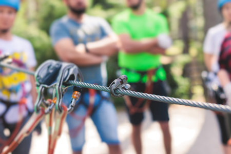 View of high ropes course, process of climbing in amusement acitivity rope park, passing obstacles and zip line on heights in climbing safety equipment gear between the trees, summer dayの写真素材