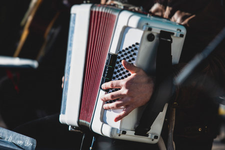 Concert view of accordion player performing on a stage with vocalist and jazz group band orchestra in the background, accordionist performance during music jazz live showの写真素材