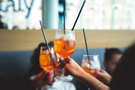 View of alcohol setting on catering banquet table, row line of orange red colored aperitif alcohol cocktails on a party, negroni, spritz and others on a decorated catering bouquet table eventの写真素材