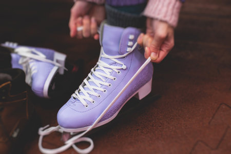 Close up view of a new purple violet pink ice skates boots on rink in motion, girl ice skating on arena, concept of ice skating in winter, holiday christmas timeの写真素材