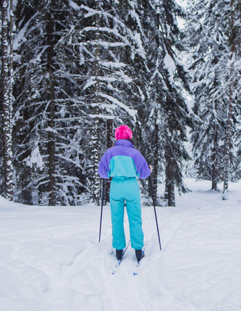 Beautiful cold forest view of ski run track on ski resort, winter day on a slope, pist, nordic skier on the track, process of cross-country skiing in the woodsの写真素材