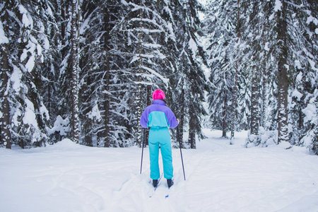 Beautiful cold forest view of ski run track on ski resort, winter day on a slope, pist, nordic skier on the track, process of cross-country skiing in the woodsの写真素材