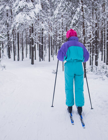 Beautiful cold forest view of ski run track on ski resort, winter day on a slope, pist, nordic skier on the track, process of cross-country skiing in the woodsの写真素材