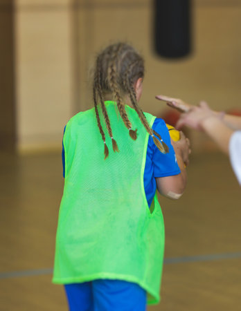 Junior teenage school team of kids children play basketball, players in the hall indoor venue court,...