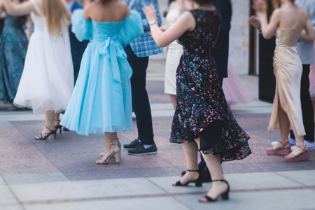 High school graduates dancing waltz and classical ball dance in dresses and suits on a school prom...