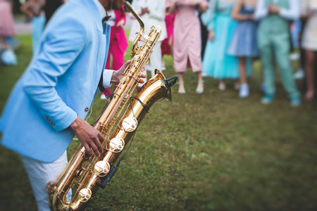 Concert view of saxophonist, a saxophone sax player with vocalist and musical band during jazz orchestra show performing music on a stage in the scene lightsの写真素材