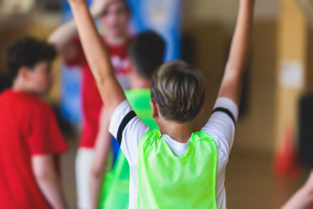 Junior teenage school team of kids children play basketball, players in the hall indoor venue court, sports team during game, playing indoor match game on arena stadium on a wooden parquet floorの写真素材