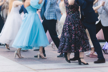 High school graduates dancing waltz and classical ball dance in dresses and suits on a school prom graduation, classical ballroom dancers dancing, waltz, quadrille and polonaiseの写真素材