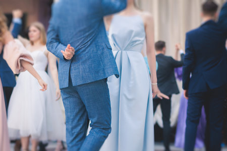 High school graduates dancing waltz and classical ball dance in dresses and suits on a school prom graduation, classical ballroom dancers dancing, waltz, quadrille and polonaiseの写真素材