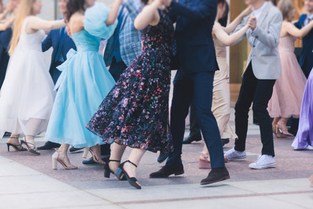 High school graduates dancing waltz and classical ball dance in dresses and suits on a school prom graduation, classical ballroom dancers dancing, waltz, quadrille and polonaiseの写真素材