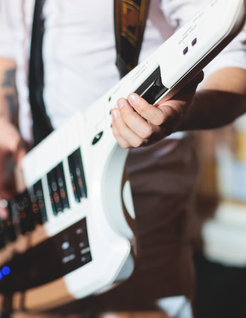 Concert view of a keytar synthesizer player with vocalist and musical jazz rock band orchestra performing in a background, electronic keyboard instrument guitar performer on stageの写真素材
