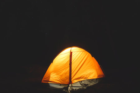 View of an orange tent under the night sky with a campfire in american campground, Yosemite National Park, California, United Statesの写真素材