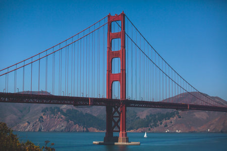 Classic panoramic view of famous Golden Gate Bridge seen from Baker Beach in beautiful summer sunny day with blue sky, San Francisco, California, USAの写真素材
