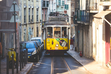 Historic famous yellow tram on the streets of Alfama Old town Lisbon, Portugal, in summer dayの写真素材