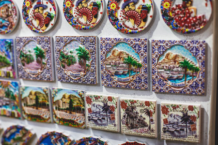 View of traditional tourist souvenirs and gifts from Spain, Alicante, Valencia with toys, bull figures, flamenco dancer dolls, fridge magnets with and key ring keychain, in local vendor souvenir shopの写真素材