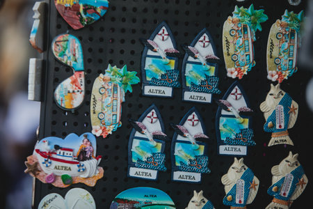 View of traditional tourist souvenirs and gifts from Altea, Alicante, Valencia with toys, fridge magnets with and key ring keychain, in local vendor souvenir shopの写真素材