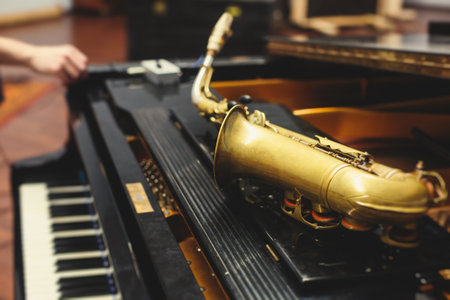 View of a saxophone player in headphones during rehearsal, recording sound for new album song at studio, saxophonist musician in front of microphone with a musical band orchestra, music productionの写真素材