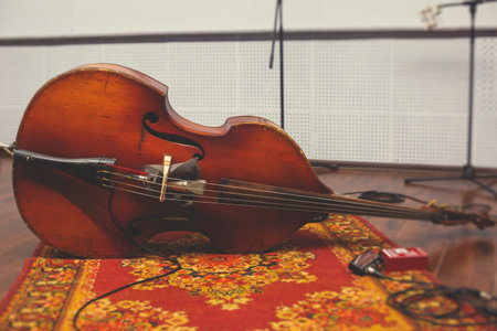 Contrabass cellist player in headphones during rehearsal, recording sound for new album song at...