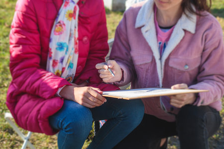 Process of plein air painting, group of young school students in the park with paints easels, and canvases during class lesson of pencil sketching painting drawings outdoors, teacher and studentsの写真素材
