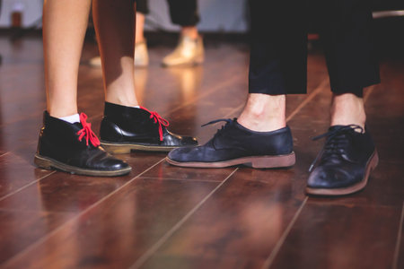 Dancing shoes of young couple dance retro jazz swing dances on a ballroom club wooden floor, close up view of a shoes, female and male, dance lessons class rehearsalの写真素材