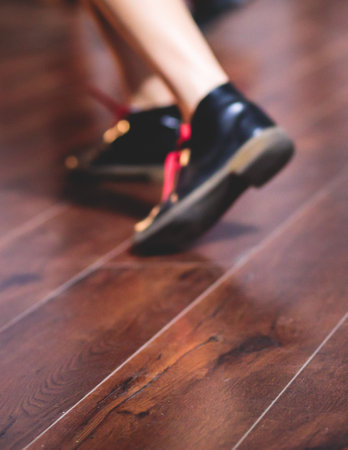 Dancing shoes of young couple dance retro jazz swing dances on a ballroom club wooden floor, close up view of a shoes, female and male, dance lessons class rehearsalの写真素材