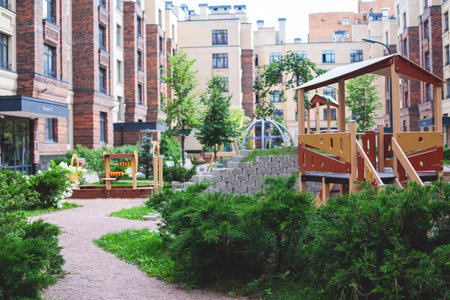Modern european residential apartment complex yard territory, multi-story house buildings with playground and benches, contemporary scandinavian housing development, facade exterior and a courtyardの写真素材