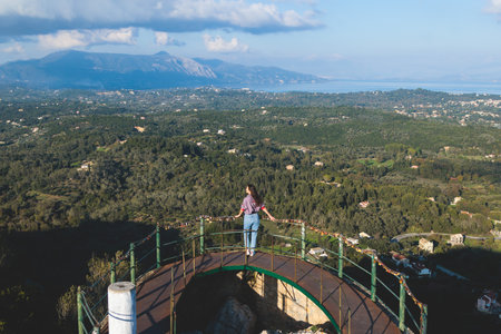 View of Kaiser's Throne observation deck lookout, Pelekas village, Corfu island, Greece, Kaiser William II summit Observatory panoramic summer view with mountains, sea and Kerkyra in the backgroundの写真素材